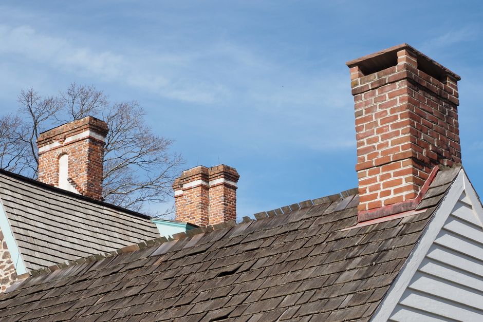 Close-up of red brick chimneys on a rustic rooftop in Horsham, PA, under a clear blue sky.